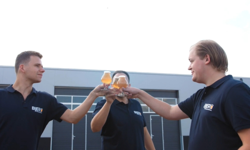 Drie mannen proosten met bier op nieuwe webshop